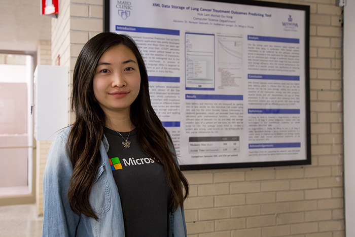 Senior Rachel OuYong from Hong Kong, China, stands in front of her senior capstone research project on XML Data Storage of Lung Cancer Treatment Outcomes Prediction Tool in computer science in collaboration with Mayo Clinic on Monday, April 24 in Watkins Hall. OuYong said her project explains software design, analysis and results for the benefits of the data storage program.