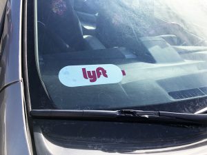 Lyft driver sticker in front of vehicle window